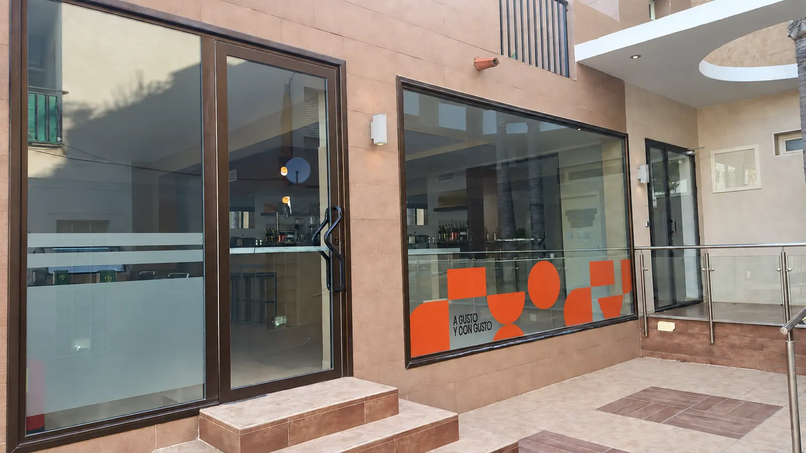 Entrance to Playa Terreros, with glass doors and the brand’s orange window graphics
