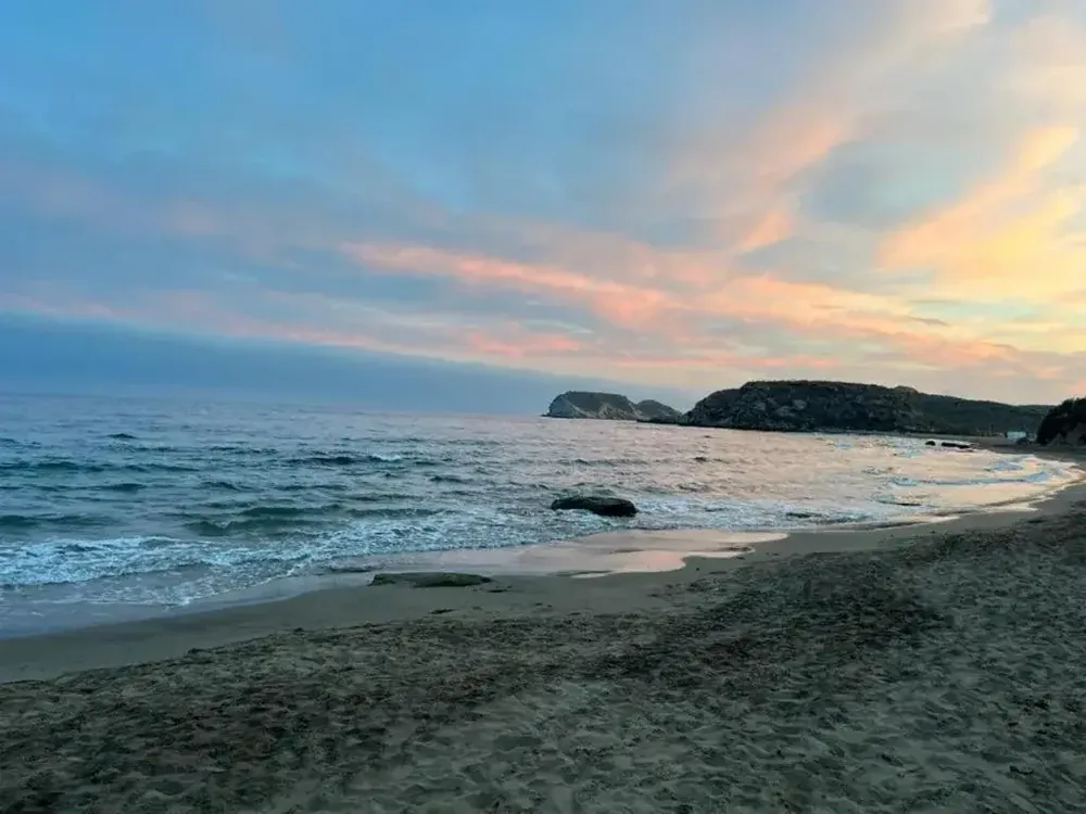 Playa de San Juan de los Terreros al atardecer, con la isla al fondo