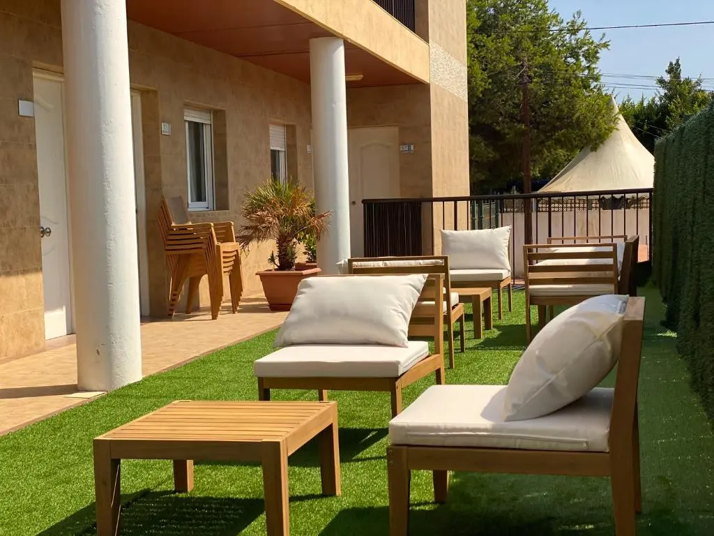 First-floor outdoor gallery with artificial grass, armchairs and a low table